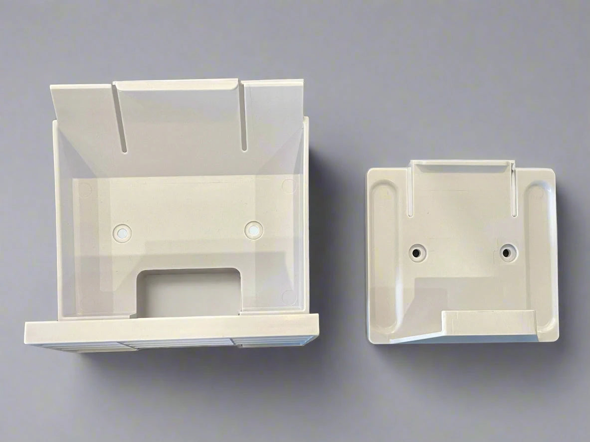 Two white plastic brackets on a dark textured surface