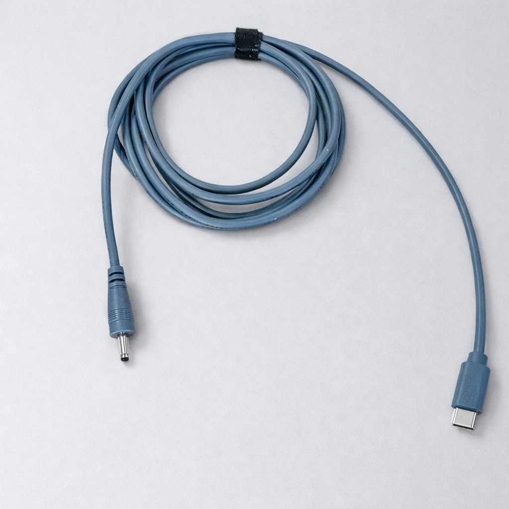 Blue-grey Spacetek charging cable coiled neatly with one end featuring a barrel plug and the other a USB-C connector, isolated on a clean grey background.