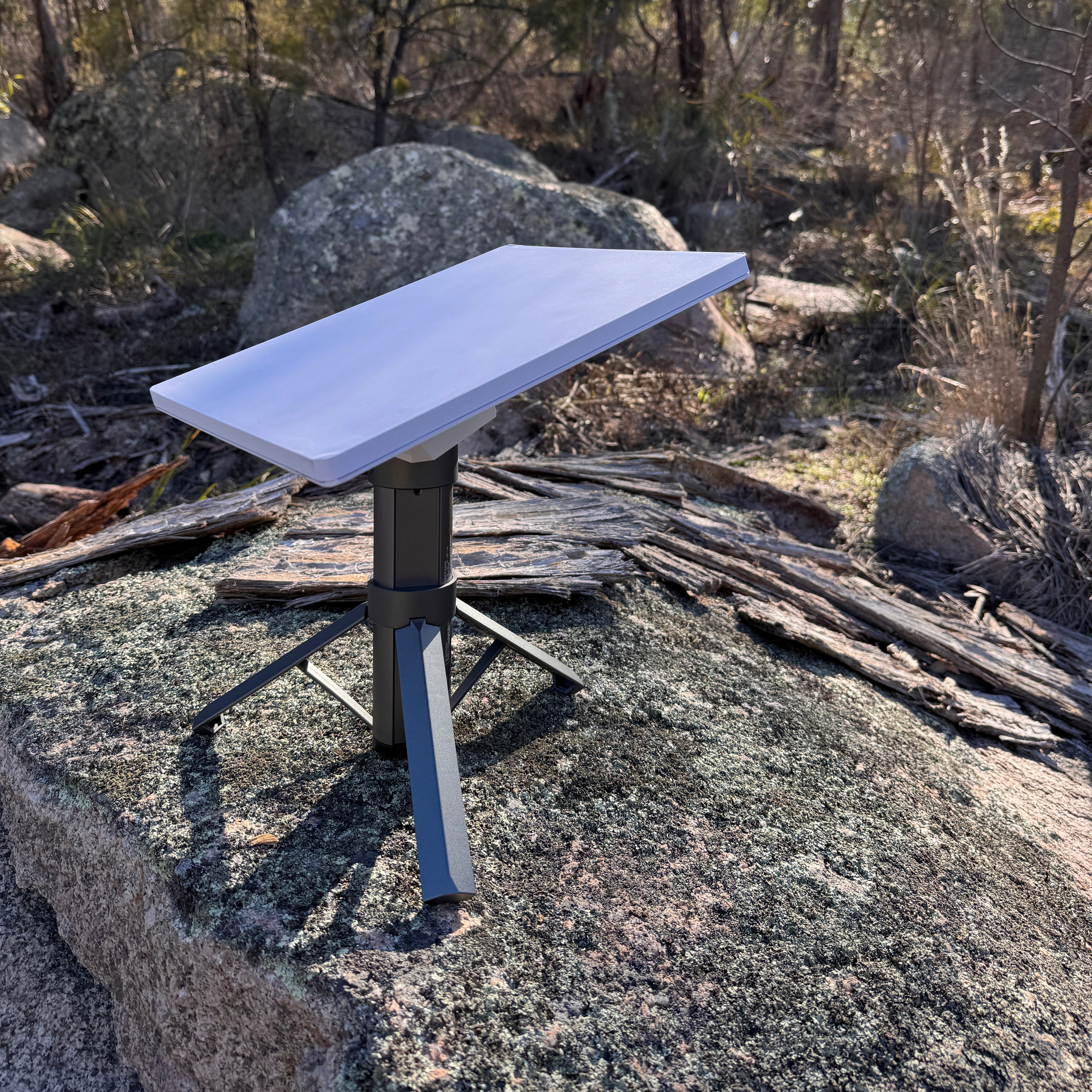 Spacetek Starlink Mini Tripod Battery 9Ah supporting a Starlink Mini in a natural bushland setting on a granite rock for portable off-grid internet