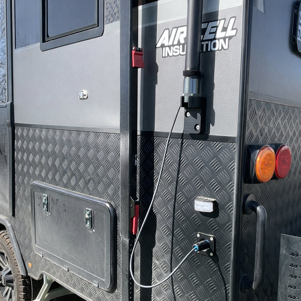 Close-up of Spacetek carbon fibre telescopic pole mounting bracket and hardware installed on caravan exterior for Starlink receiver