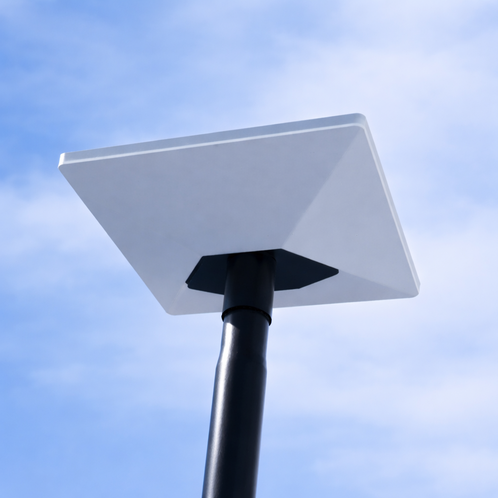 Starlink Mini satellite dish mounted on a carbon fibre Spacetek pole, photographed from below against a blue sky