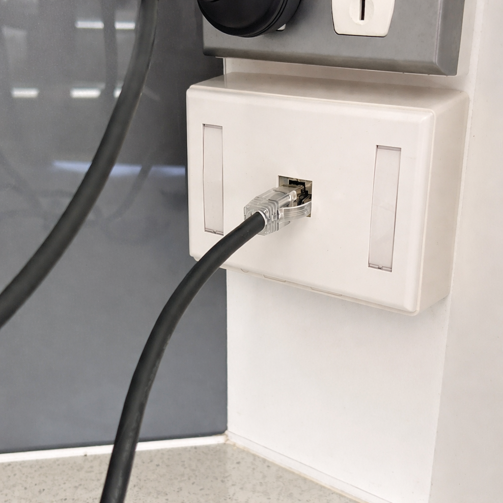 CAT6 Ethernet wall outlet with network cable plugged into keystone jack