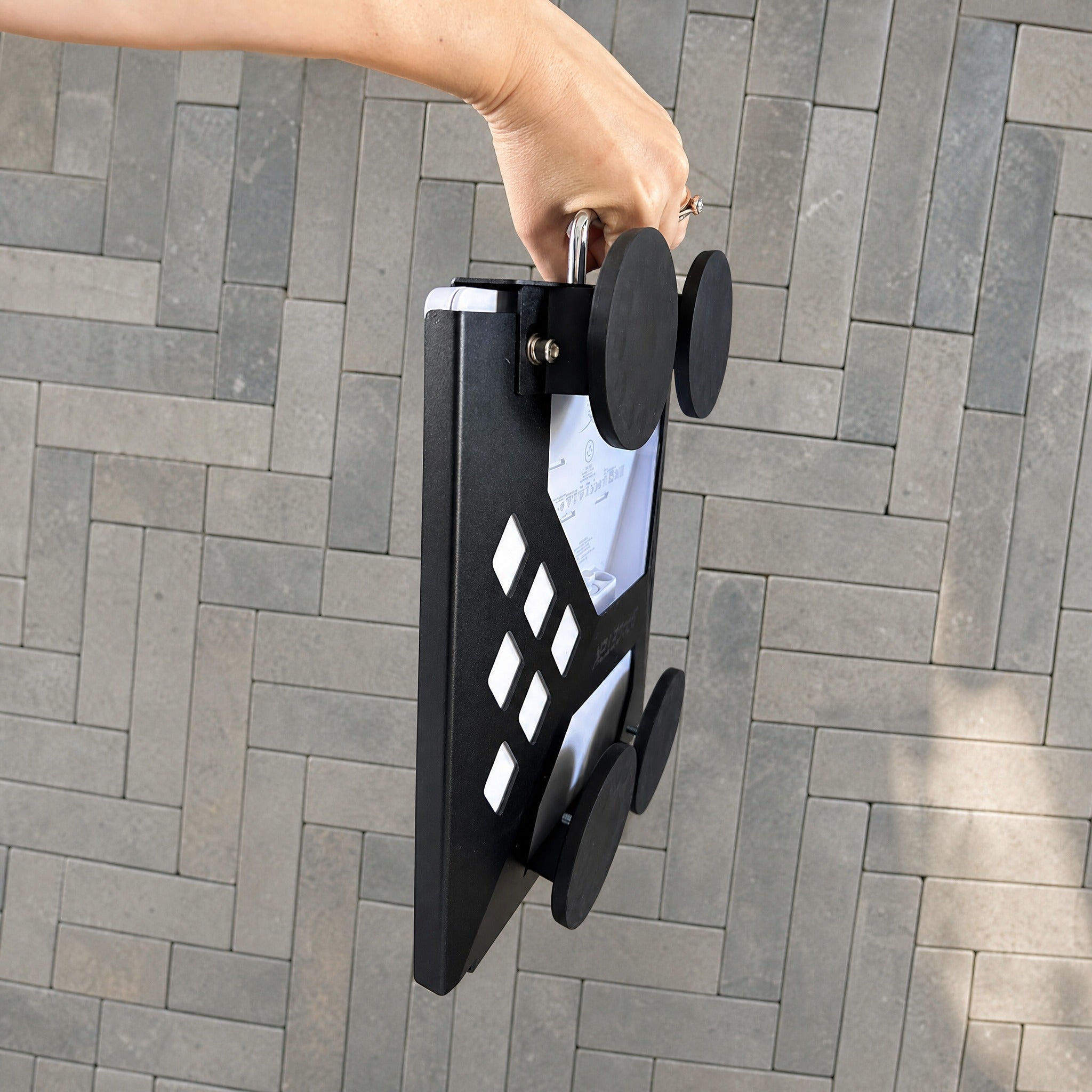 Black Starlink Mini robust magnetic mount being carried by hand for portable vehicle and travel use