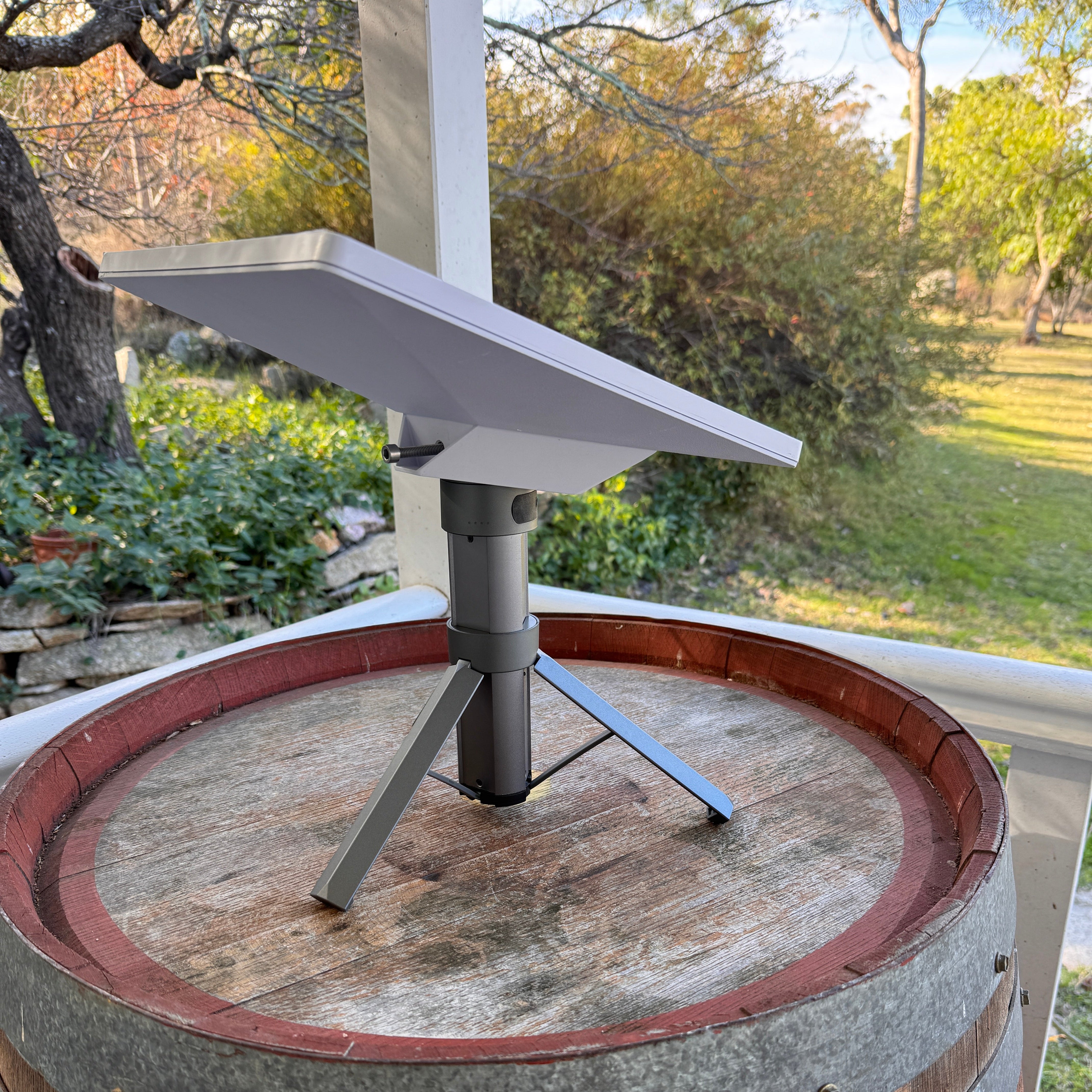 Angled outdoor view of the Spacetek Starlink Mini Tripod Battery 9Ah with Starlink Mini mounted on a patio, highlighting the compact tripod design
