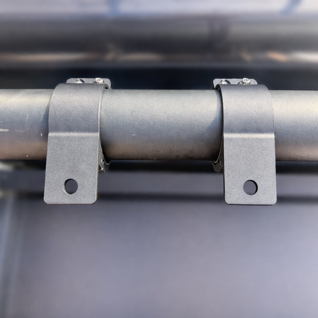 Two Starlink Mini compatible tube mount clamps installed on a roof rack crossbar for mounting Starlink Mini accessories.