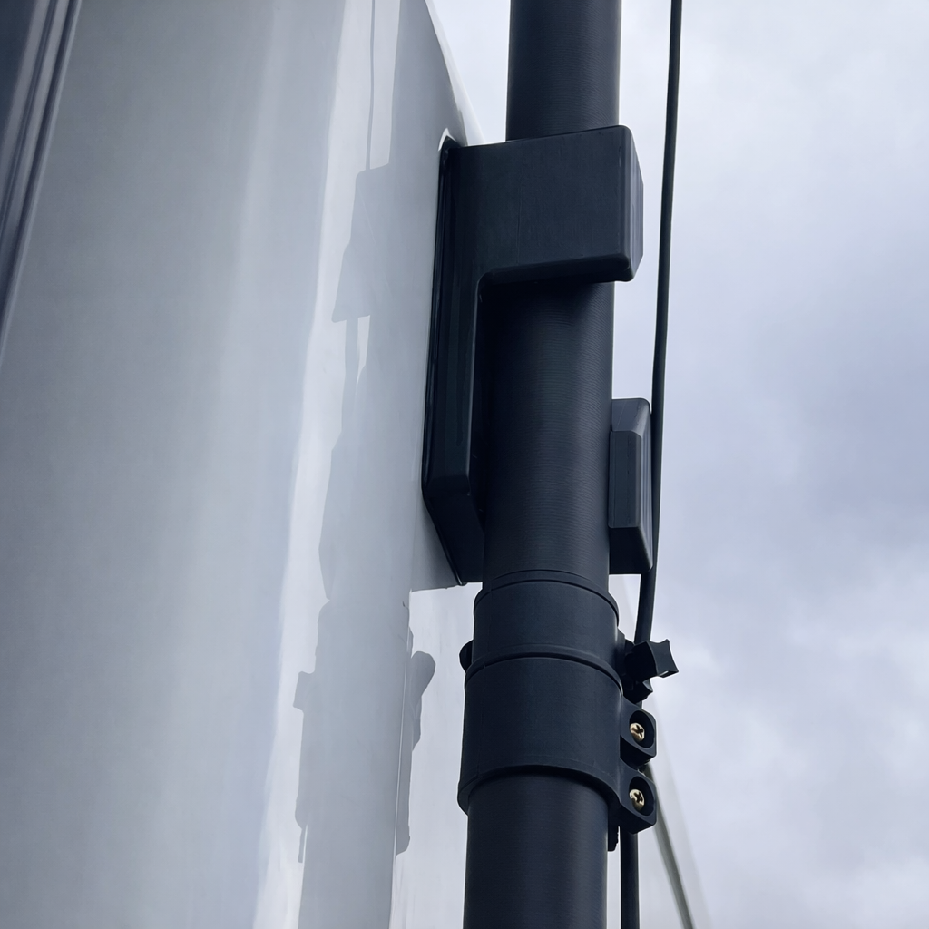 Spacetek carbon fibre telescopic pole secured to caravan side wall using heavy-duty mounting bracket and hardware for Starlink receiver.